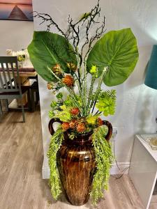 a vase filled with flowers and leaves in a room at Relax 521 in Miami
