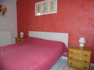 a bedroom with a pink bed and a red wall at Appartement Canet-Plage, 2 pièces, 4 personnes - FR-1-750-6 in Canet-en-Roussillon