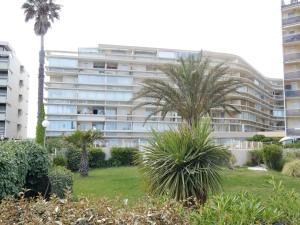 a large building with palm trees in front of it at Appartement Canet-Plage, 2 pièces, 5 personnes - FR-1-750-35 in Canet-en-Roussillon