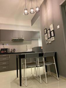 uma cozinha com uma mesa preta e cadeiras em Apartment Mahkota Melaka Room 3062 em Malaca