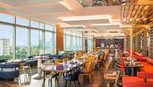 a restaurant with tables and chairs and large windows at W Suzhou - Jinji Lake in Suzhou