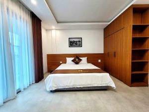 a bedroom with a large bed and a large window at Swan Motel in Ha Long