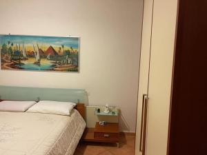 una camera da letto con un letto e un dipinto sul muro di Appartamento a Castiglione del Lago
