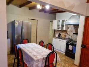 a kitchen with a table and a stainless steel refrigerator at Cabañas La Marca in San Pedro de Atacama