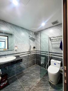 uma casa de banho com um chuveiro, um WC e um lavatório. em Swan Motel em Ha Long