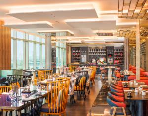 a restaurant with tables and chairs and windows at W Suzhou - Jinji Lake in Suzhou