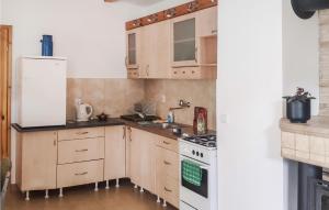 a kitchen with wooden cabinets and a white refrigerator at 2 Bedroom Pet Friendly Home In Popowo-letnisko 
