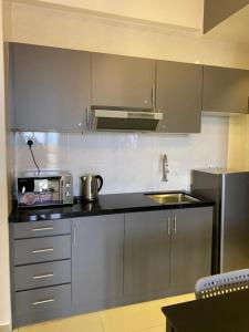 uma cozinha com armários de aço inoxidável e um micro-ondas em Apartment Mahkota Melaka Room 3062 em Malaca