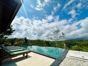 a swimming pool with a view of the mountains at Green Coco Suite in Nusa Penida