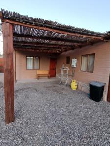 eine hölzerne Pergola an der Seite eines Gebäudes in der Unterkunft Cabañas La Marca in San Pedro de Atacama