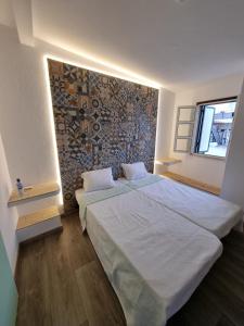 una camera con due letti e un muro di pietra di Wonder Charm Guesthouse ad Albufeira