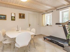 ein Esszimmer mit einem Tisch, Stühlen und einem Laufband in der Unterkunft Holiday home Rødby III in Rødby
