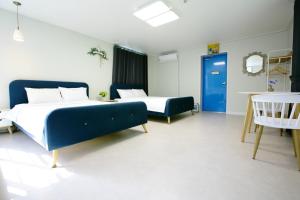 潭陽的住宿－Damyang Thirasia Pension，一间卧室设有两张床和一扇蓝色的门