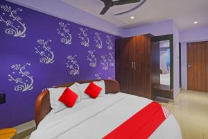 a bedroom with a large bed with red pillows at Flagship Hotel Happy Stay in Surat