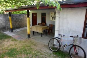 a bike parked outside of a house with a table at Meera Homestay in Anuradhapura