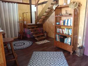 una sala de estar con una estantería con libros en Chalet chez Téra'i, en Avatoru