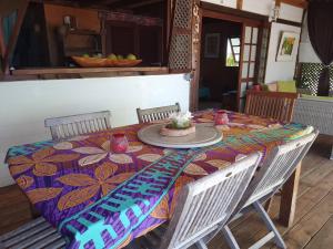 a dining room table with a colorful table cloth and chairs at Chalet chez Téra'i in Avatoru