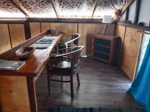 een kamer met een houten tafel en 2 stoelen bij Chalet chez Téra'i in Avatoru