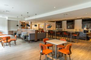 a restaurant with tables and chairs and a bar at Holiday Inn Houston West Energy Corridor, an IHG Hotel in Houston