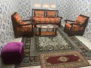 ein Wohnzimmer mit 2 Stühlen und einem Sofa in der Unterkunft Maison-villa familiale in Azemmour