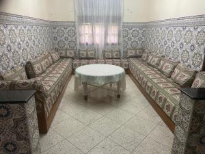 ein Wohnzimmer mit einem Sofa und einem Tisch in der Unterkunft Maison-villa familiale in Azemmour