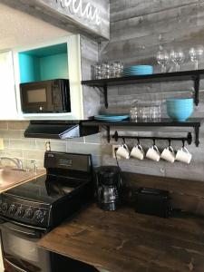 a kitchen with a stove top and a microwave at Flip Flop at Compass Cove in Myrtle Beach