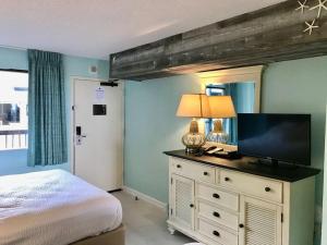 um quarto com uma cama e uma televisão numa cómoda em Flip Flop at Compass Cove em Myrtle Beach