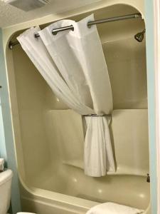 a bath tub with a shower curtain and a toilet at Flip Flop at Compass Cove in Myrtle Beach
