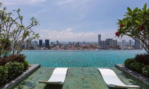 a swimming pool with two chairs and a city skyline at SkyPool with Seaview 8pax Beacon Executive Suites - Georgetown City Centre - 3km to Komtar in George Town