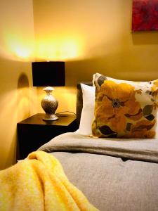 a bed with a pillow and a nightstand with a lamp at Noosa Hinterland Retreat in Tinbeerwah