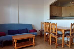タリファにあるApartamento Tortuga Verdeのリビングルーム(青いソファ、テーブル、椅子付)
