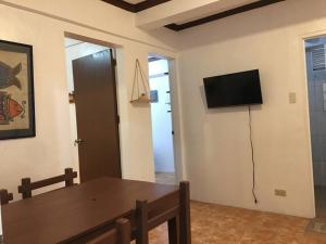 uma sala de estar com uma mesa e uma televisão na parede em Casa de Primera B31 beach front station 3 em Boracay