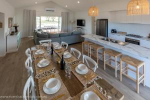 een keuken en een woonkamer met een tafel en stoelen bij Pina Colada Shack-40 Marina Way in Mannum