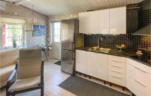 a kitchen with white cabinets and a stainless steel refrigerator at Gorgeous Home In Boxholm With House Sea View in Boxholm