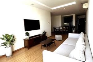 a living room with a white couch and a flat screen tv at ChouChou Apartment in Danang