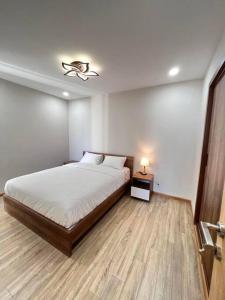 a bedroom with a bed and a night stand with a lamp at ChouChou Apartment in Danang +14 photos