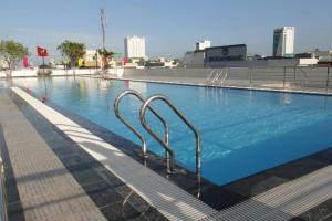 a large swimming pool with metal hand rails in it at ChouChou Apartment in Danang