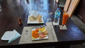 een tafel met een bord eten en een glas sinaasappelsap bij castle palace kandy in Kandy