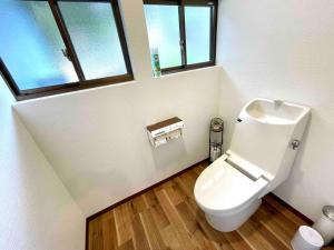 a bathroom with a toilet and two windows at 一棟貸別荘 Oceanic Villa Minamiizu!17名まで!弓ヶ浜海水浴場まで徒歩6分 in Minamiizu +46 photos