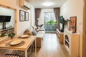 een woonkamer met een bank en een tafel bij Cozy Apartment in Sukhumvit in Bangkok
