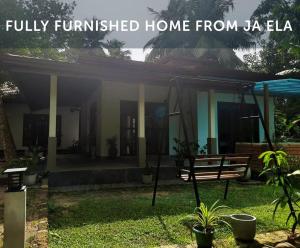 una casa con un banco en un patio con las palabras "hogar totalmente amueblado desde la en Fully Furnished house for rent in Gampaha/Ja-ela (Colombo), en Gampaha