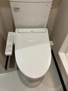 a white toilet in a bathroom with a remote control at H,U,B Unzen - Vacation STAY 78660v in Unzen