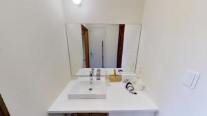 ein Badezimmer mit einem weißen Waschbecken und einem Spiegel in der Unterkunft H,U,B Unzen - Vacation STAY 78660v in Unzen