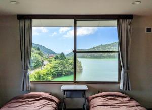 una camera da letto con una grande finestra con vista sul fiume di H,U,B Unzen - Vacation STAY 78660v a Unzen