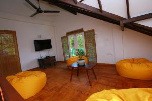 a living room with two orange chairs and a table at Ceylon House By Sunrise in Ella