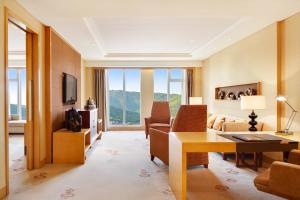 Sheraton Wuxi Binhu Hotel في ووشي: غرفة معيشة مع أريكة وطاولة في غرفة