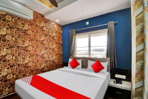 a bedroom with a bed with blue walls and red pillows at OYO Flagship Hotel 7 Star in Udaipur