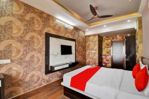 a bedroom with a bed and a tv on a wall at OYO Flagship Hotel 7 Star in Udaipur