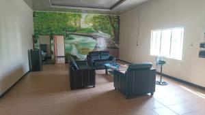 Zimmer mit Sofas und Wandgemälde in der Unterkunft Unterkunft in der Nähe des Flughafens Kuala Namu Medan in Kampungbesar