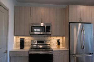 cocina con nevera de acero inoxidable y microondas en Spacious Stay, en Fort Worth